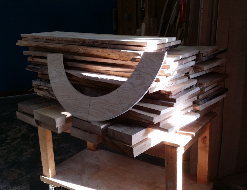 Pièces de charpente courbes en bois, présentées dans l’atelier